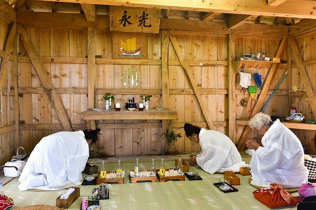 在干立御嶽進行Shimafusara祈禱的神司們。祭壇上掛著山原船的圖畫，2019年11月11日，竹富町西表島干立村（筆者攝影）