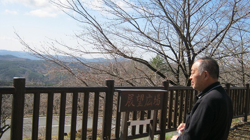Nagadoro hamlet headman Shigihara Yoshitomo looks toward the sea, which is just visible between a gap in the mountains. Many from Nagadoro blame that gap for allowing radiation to reach the hamlet.