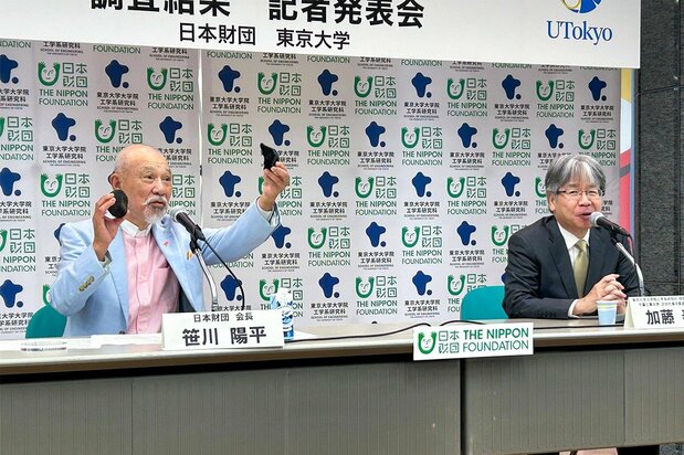 南鳥島沖の海底から引き揚げられた「マンガンノジュール」を手にする日本財団の笹川陽平会長(左)と東京大学大学院の加藤泰浩教授=2024年6月21日、東京都港区の日本財団(撮影:ニッポンドットコム編集部)