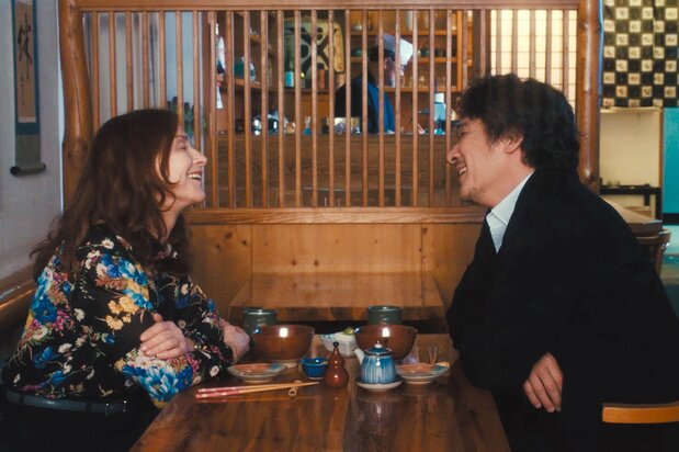 居酒屋で打ち解けるシドニと健三。撮影は日本以外にフランスとドイツでも行われた © 2023 10:15! PRODUCTIONS / LUPA FILM / BOX PRODUCTIONS / FILM IN EVOLUTION / FOURIER FILMS / MIKINO / LES FILMS DU CAMELIA