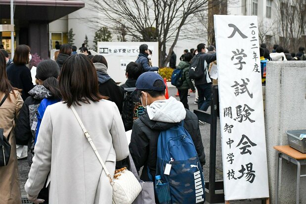 Los estudiantes que se presentaron al examen de acceso a secundaria el 10 de enero de 2022 entran en el campus de Kaichi, en la ciudad de Saitama, con sus padres. (© Saitama Shimbun)