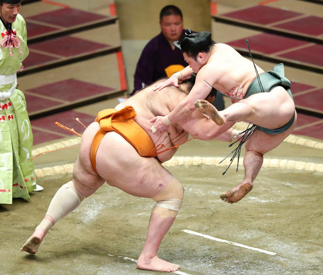 2020年11月場所、魁聖（左）との立ち合いで八艘飛びを見せる炎鵬。168cm・99kgの体型は舞の海とほぼ同じ。「舞の海さんの相撲を参考にした」とコメントした（2020年11月9日、東京・両国国技館） 時事