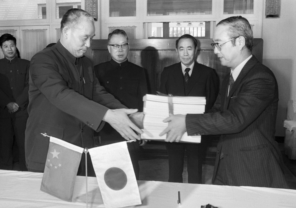 三江平原開発調査報告書を中国農業工程設計研究院副院長張（左）に手渡す農林水産省建設部長須藤良太郎（右）　1984年3月27日　北京市　共同