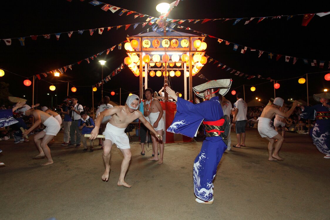 上半身裸の男性が竹筒のアヤ棒を持って女性と2人一組で踊る「アヤ踊り」