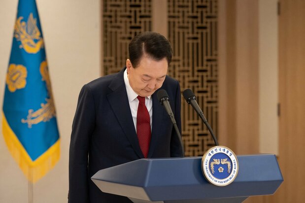 ソウルの大統領府で演説中に頭を下げる韓国の尹錫悦大統領。同時に「最後の瞬間まで戦う」と誓い、自らの行為を正当化した=2024年12月12日、韓国大統領府提供(AFP=時事)