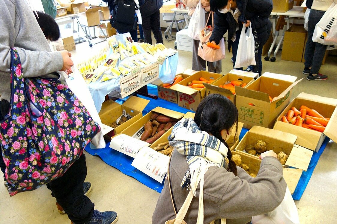 農家が提供するじゃがいもを手にする学生、相模原市の学生支援会で（筆者撮影）