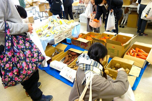 農家が提供するじゃがいもを手にする学生、相模原市の学生支援会で（筆者撮影）