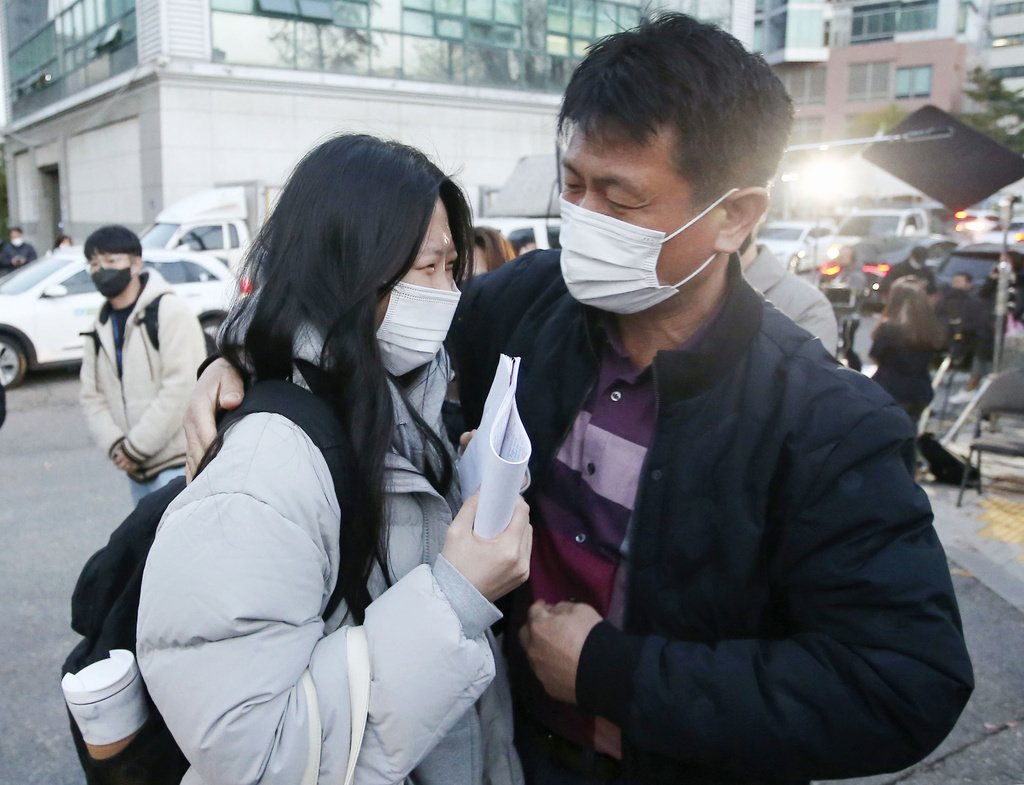 親に見送られ試験会場に向かう受験生＝ソウル（共同）