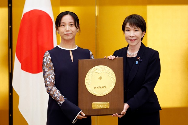 首相官邸での表彰式で、高市早苗首相から盾を授与された高木選手［代表撮影］（AFP=時事）