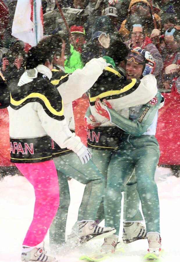 Funaki Kazuyoshi (derecha) y el resto del equipo japonés estallan de alegría tras ganar la medalla de oro de salto de esquí con trampolín grande masculino por equipos. (Jiji Press)