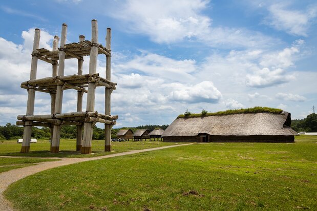 A towering pillar-supported structure, left, and reconstructed pit dwelling have come to symbolize the Sannai Maruyama site.