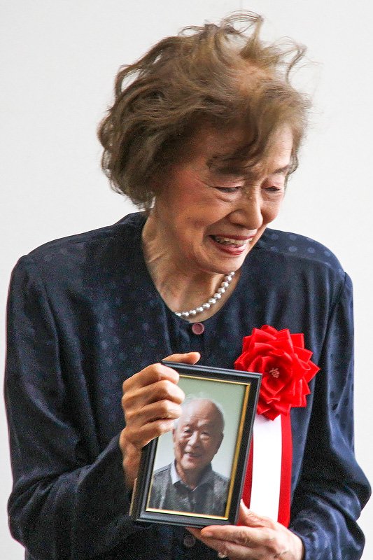 Mura Nunoe sostiene una fotografía de su esposo, Mizuki Shigeru, en una ceremonia tras las reformas en el aeropuerto de Yonago Kitarō el 8 de marzo de 2016.