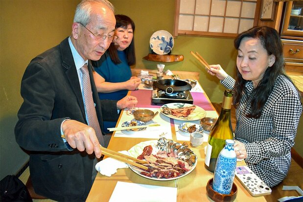 A regular customer grills mallard caught and frozen by the Hattoris on April 10, 2024, at Yamadori. (© Izumi Nobumichi)