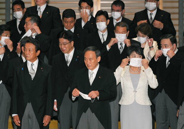 在皇居参加首相亲任仪式和阁僚认证仪式,并拍照留念后,首相菅义伟(前排中)和众阁僚一边佩戴口罩一边等车,2020年9月16日,皇居(时事社)