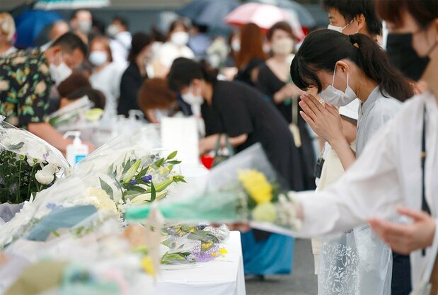 故安倍晋三元首相に弔意を示すため、自民党本部に設けられた献花台で手を合わせる人たち=2022年7月15日午後、東京・永田町(時事)