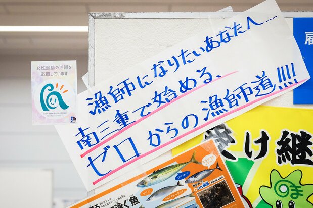 Muchos stands del evento exhibían la pegatina “Apoyamos a las mujeres pescadoras”, que se ve aquí arriba a la izquierda. (© nippon.com)