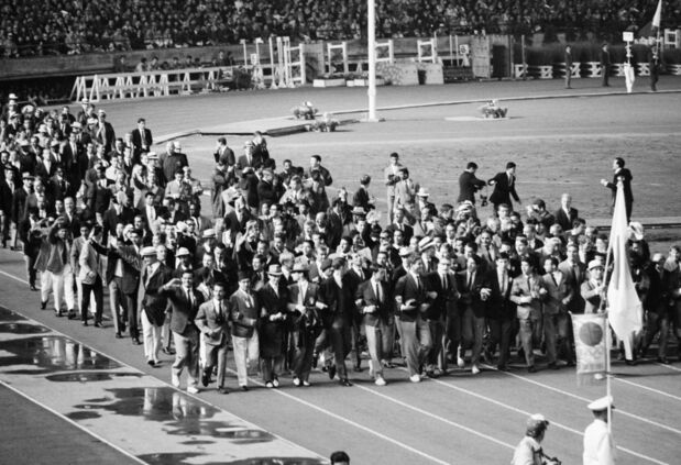 Cérémonie de clôture des Jeux olympiques de Tokyo de 1964. Les athlètes de tous les pays participants paradent en se tenant les bras (Jiji Press)