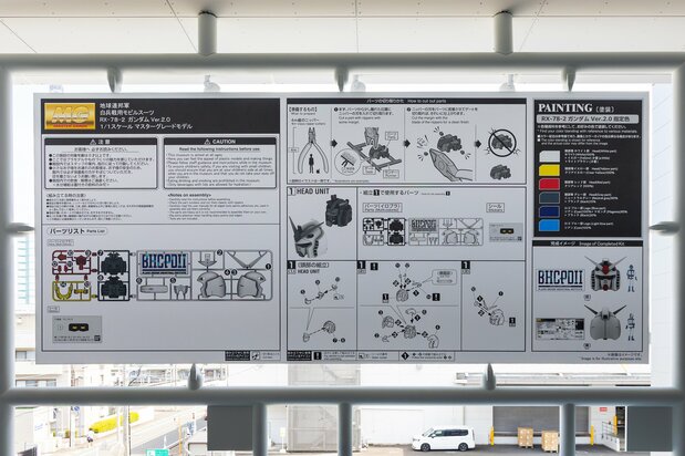Panels in the rear corridor list parts and assembly instructions, complete with tongue-in-cheek notes like “Items to Prepare: 4-meter nippers.” (© Sōtsū/Sunrise, © Nippon.com)