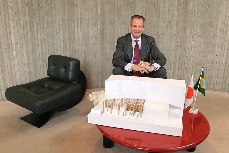 El embajador Corrêa do Lago sentado detrás de una maqueta del pabellón diseñado por el arquitecto japonés Ban Shigeru, recientemente galardonado por el Premio Pritzker. (Izquierda) Silla diseñada por el arquitecto brasileño Oscar Niemeyer.