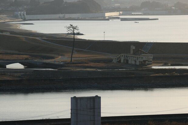 東日本大震災の発生から10年を迎えた陸前高田市の「奇跡の一本松」(中央左)と震災遺構「陸前高田ユースホステル」(同右)=2021年3月11日、岩手県陸前高田市(時事)