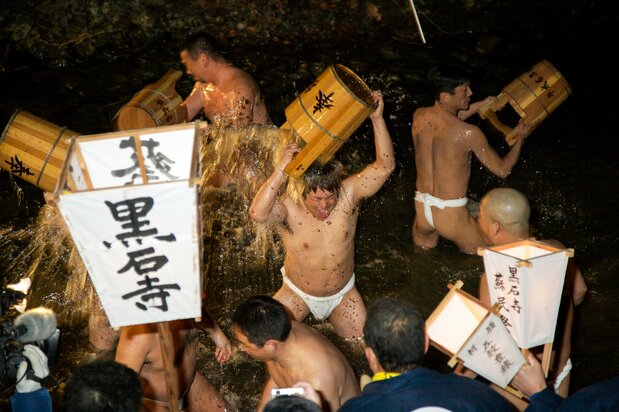 东北地区2月的夜晚,参加者在冰冷的河水中净身
