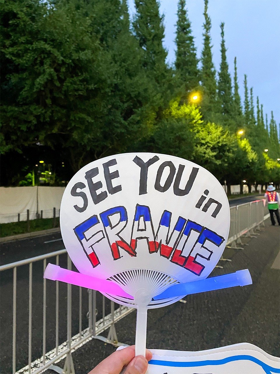 閉会式の日、「See You in France」のうちわを持つ筆者