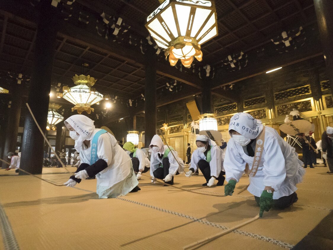 西本願寺のお煤払いで畳を竹の棒で叩く女性たち