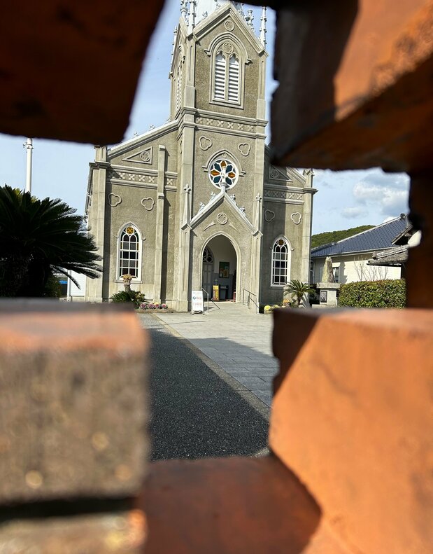 La iglesia desde una abertura en forma de cruz en un muro de ladrillo de las cercanías. Es un ángulo muy popular para tomar fotografías y compartirlas luego en las redes sociales. (Fotografía: Amano Hisaki)