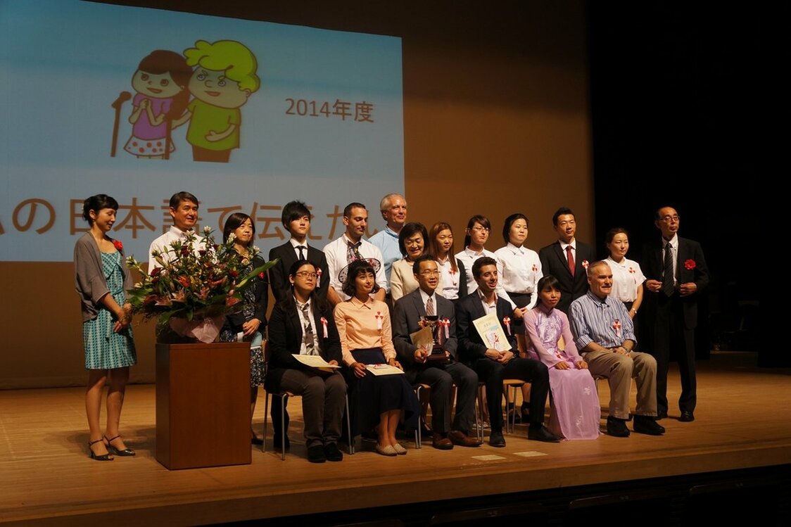 Staff, judges, and guest speakers join the 11 contestants on stage at the Naganuma School Speech Contest 2014, themed “Nihongo de tsutaetai” (What I Want to Say in Japanese).