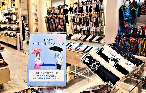 Advertising at Matsuya Ginza urges customers to stay apart with parasols. (Photo courtesy of the author)