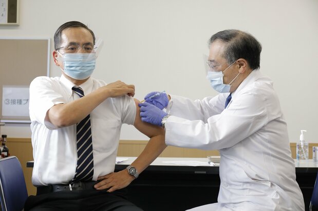 Araki Kazuhiro (left), the head of the National Hospital Organization Tokyo Medical Center, receives the first COVID-19 vaccination on February 17, 2021. (© Jiji)