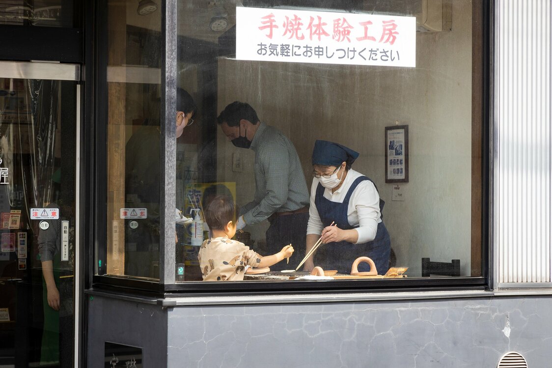 可以从玻璃窗外观看顾客亲自烤制煎饼的场景。记者结束采访后，立刻有小朋友前去尝试