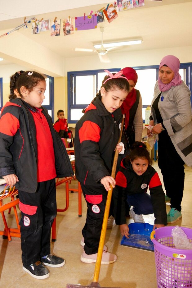 Classroom cleaning. Some pupils disliked the idea at first, but now most participate in this activity meant to teach teamwork.