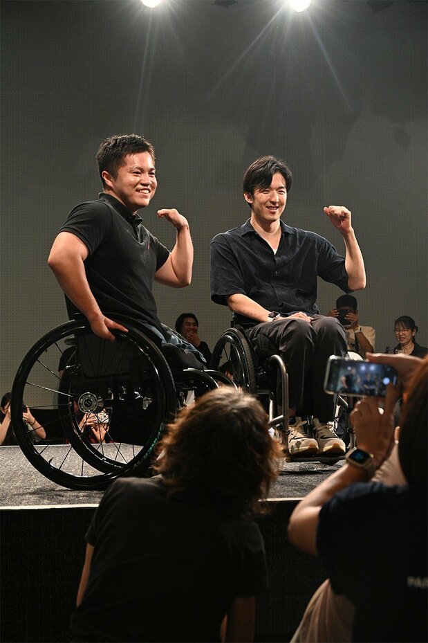 Wheelchair rugby team members Hashimoto (left) and Nakamachi. Ōsato says she “wanted to photograph the two athletes smiling at the camera and the cheering audience to express the wide support they have.” (© Ōsato Mirei)