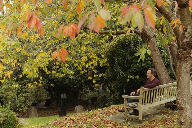 Lev Parikian takes a break during his daily walk in the cemetery near his home.