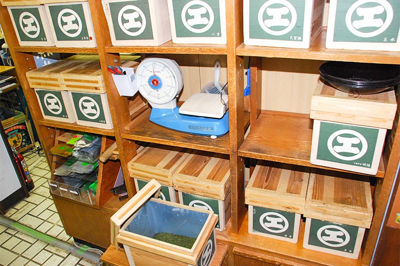 量り売りに用いる計量器の周りには、古くから使われてきた「エ」のシンボルマークをあしらった木製茶箱が並べられていた