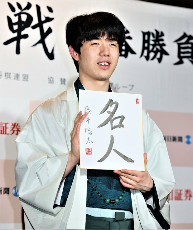 最年少名人と七冠を達成し、記者会見で色紙を手にする藤井聡太七冠（2023年6月1日、長野県高山村） 時事