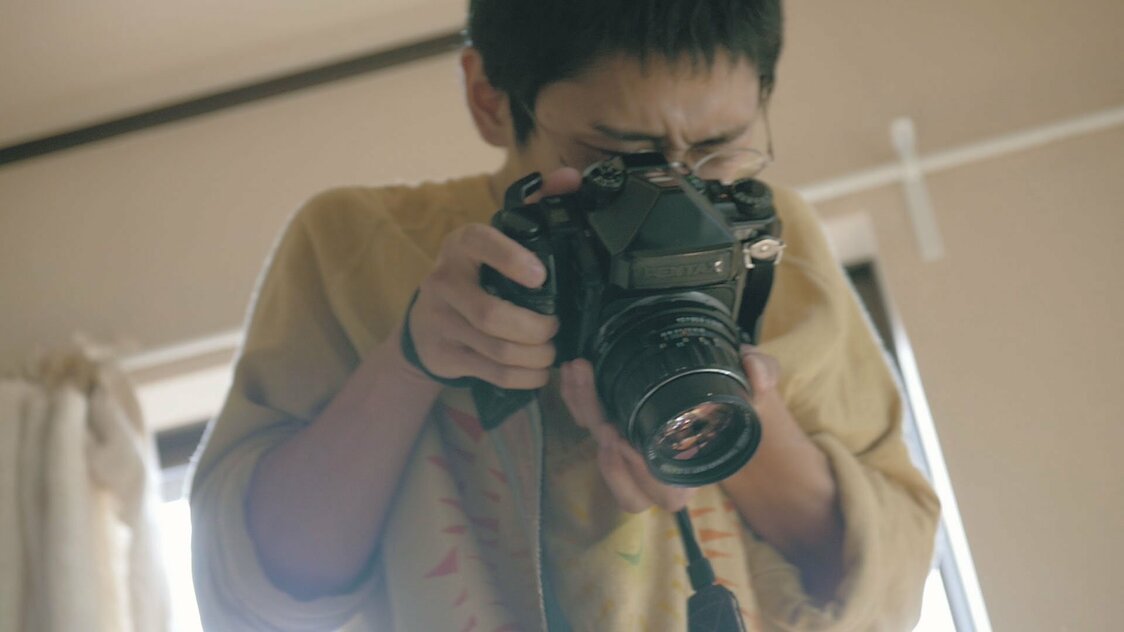 出産を終えた妻と生まれた子どもにシャッターを切る齋藤　©2020 hiroki kawai／SPACE SHOWER FILMS
