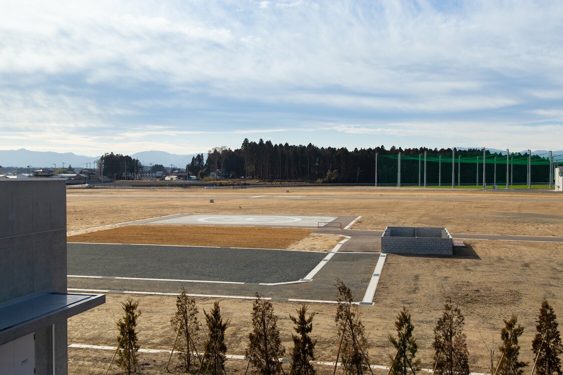 西側のヘリポートや滑走路の向こうに林が見える。海から約1.4キロ離れたこの林の辺りまで、津波が押し寄せたという