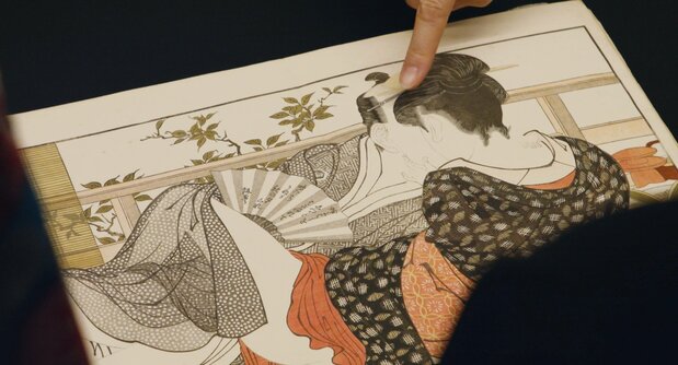 Le « Chant de l’oreiller » (Uta-makura), chef-d’œuvre du genre peint par Kitagawa Utamaro (1753-1806), était l’un des clous de l’exposition du British Museum. On distingue en haut de la photo un expert montrant du doigt les yeux plissés du personnage ne faisant plus qu’un avec les cheveux de son amante. (© 2023 Shunga Production Committee)