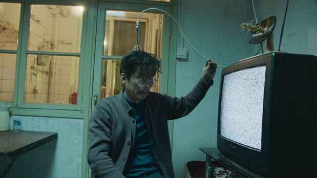 「宇宙の異常な波動はテレビの砂嵐を通じて観測できる」とタンは力説する　©G!FILM STUDIO[BEIJING]Co.,LTD. ALL RIGHTS RESERVED.