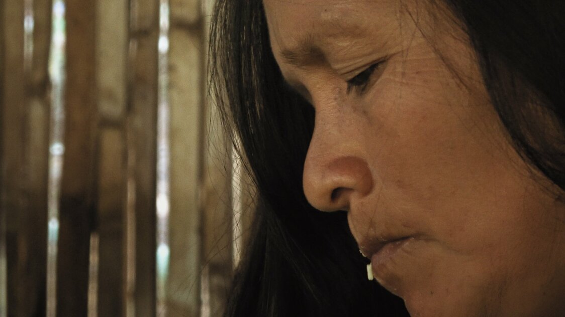 Pastora, la femme du chef du village, mâche du manioc et le recrache en préparation de la chicha. (© Akimi Ota)