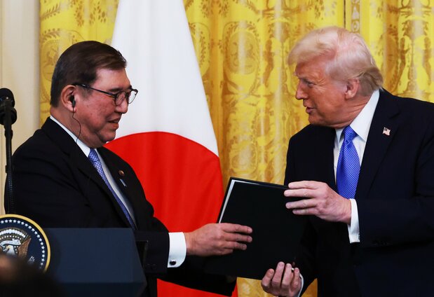 /cap/ Prime Minister Ishiba Shigeru (left) receives a commemorative gift from President Donald Trump at a joint press conference following the US-Japan summit, April 7, 2025, in Washington DC. (© Jiji)