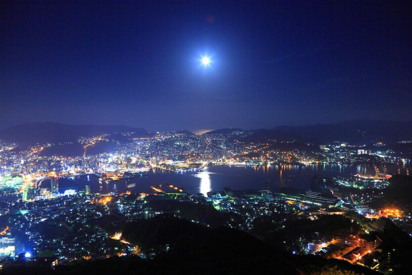 稲佐山展望台から眺める満月と海に現れる月明かりの道(長崎県)。