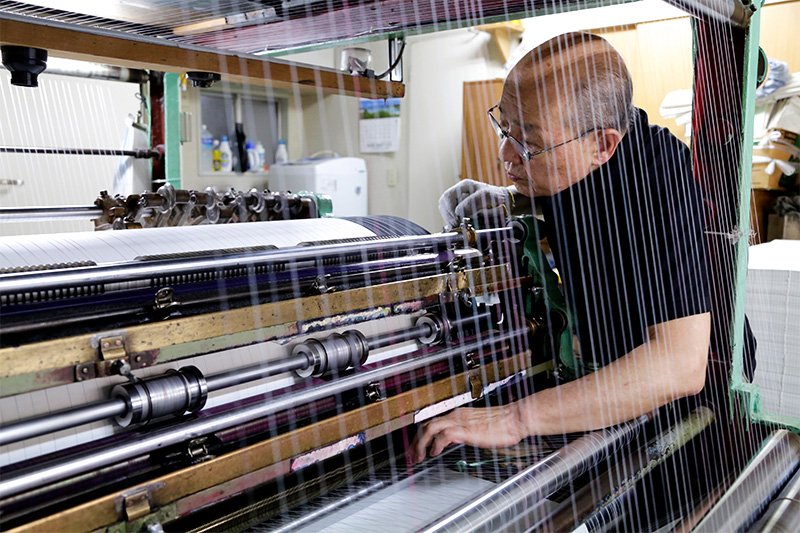 Machine operator Iguchi Hiroshi checks that everything is moving along smoothly.