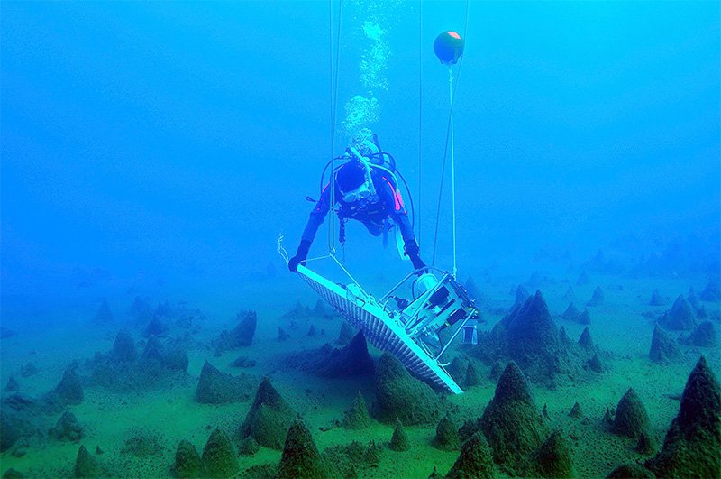 Installation d’un système de vidéo sous-marin pour observer les « cônes de mousse » au fond d’un lac, en janvier 2010.