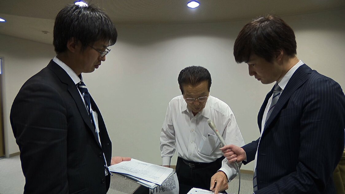 五本市議に迫る砂沢（左）と五百旗頭