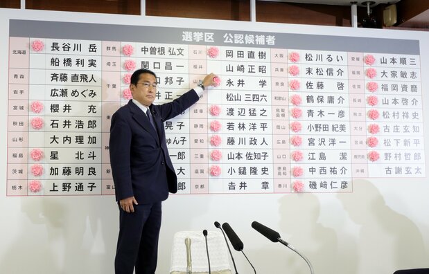 首相岸田文雄给所有已确定当选的候选人贴花（2022年7月10日晚，东京都千代田区，时事社）