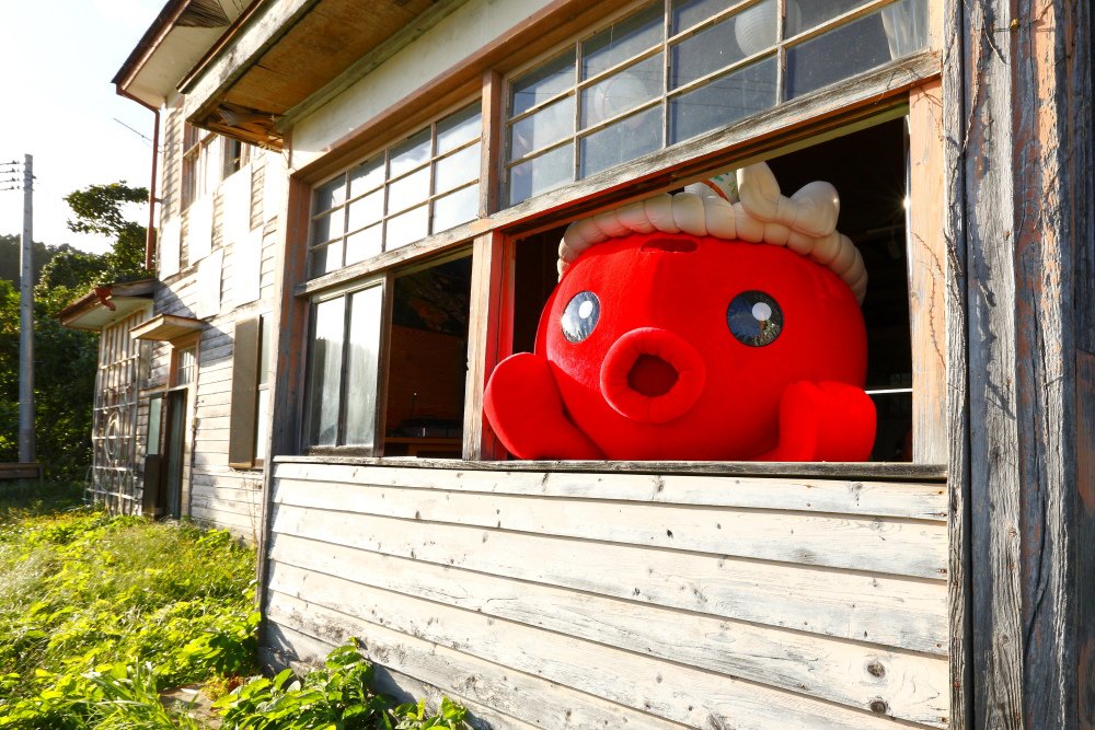 La mascotte Octopus-kun en peluche se montre par la fenêtre de l’ancien collège Iriya (photo avec l’aimable autorisation de Minami-Sanriku Fukkô-dako no kai).