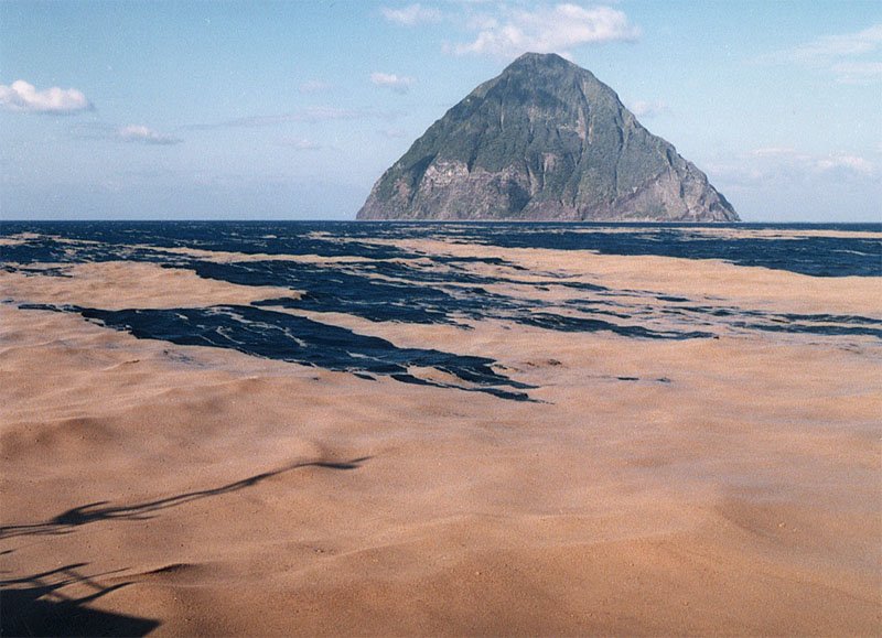 Durante otra erupción en 1986, una gran cantidad de piedra pómez llenó la superficie del mar. La isla que se divisa a lo lejos es Minami-iōtō. (Por cortesía de la Guardia Costera de Japón)